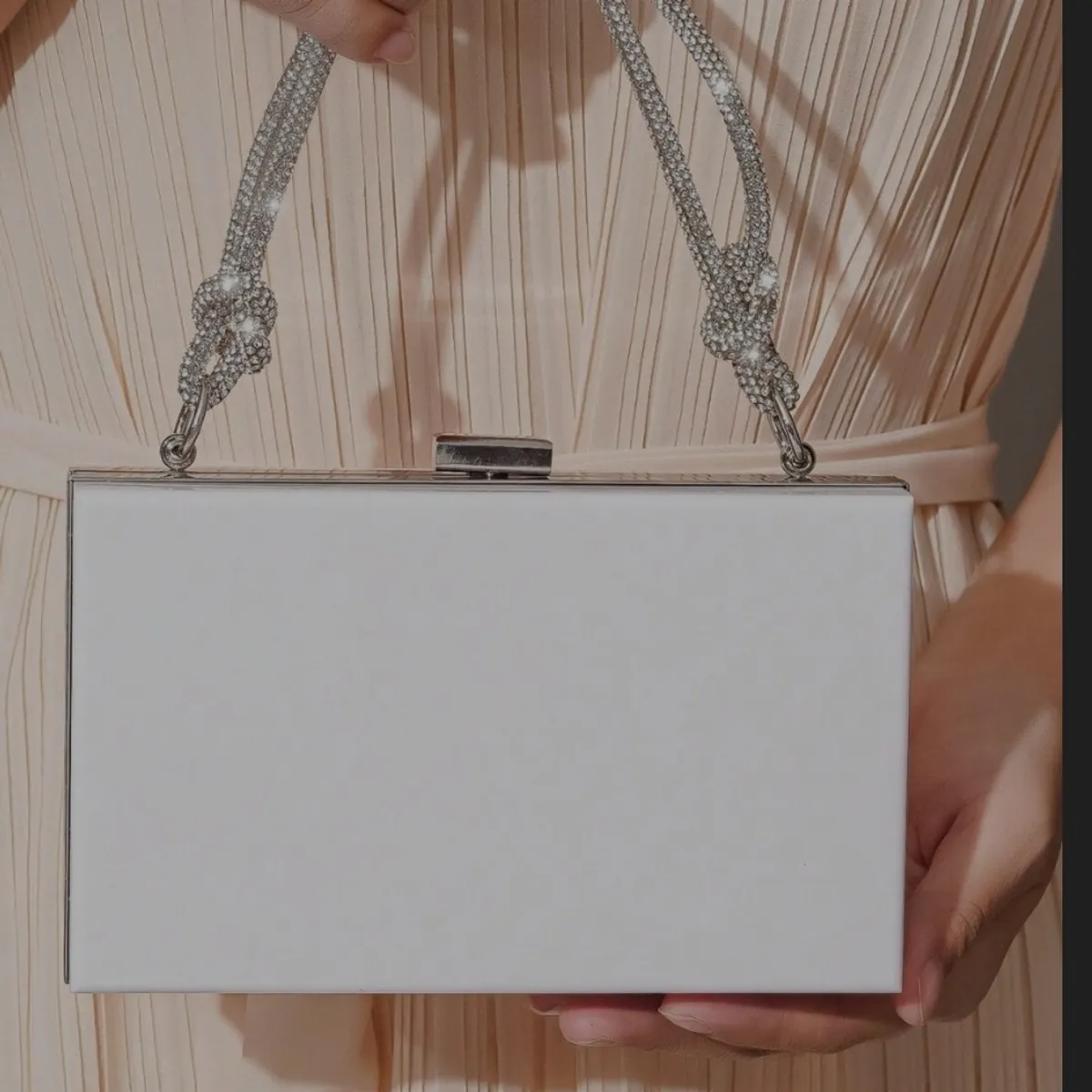Women's white acrylic clutch features a distinctive rhinestone-encrusted top handle