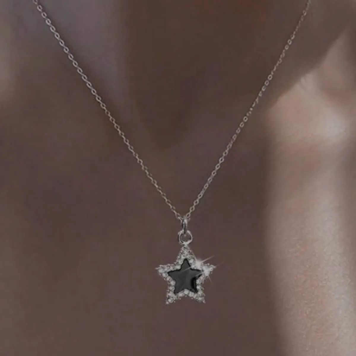 Silver-tone star Necklace features a black Enamel Center surrounded by small clear stones